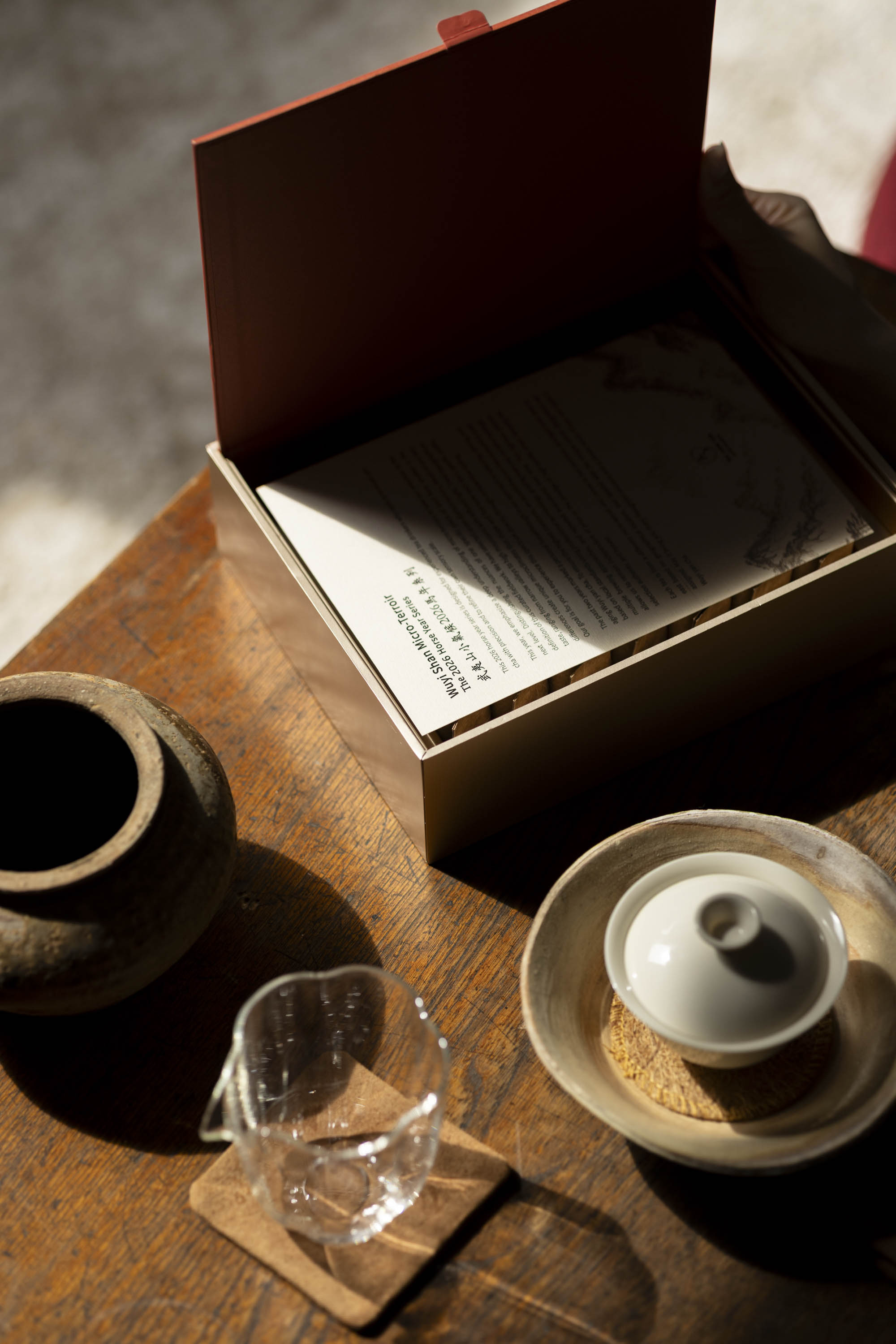 An open hyt Wuyi Yancha 2026 Horse Year wulong tea box displaying its introduction card on a wooden table