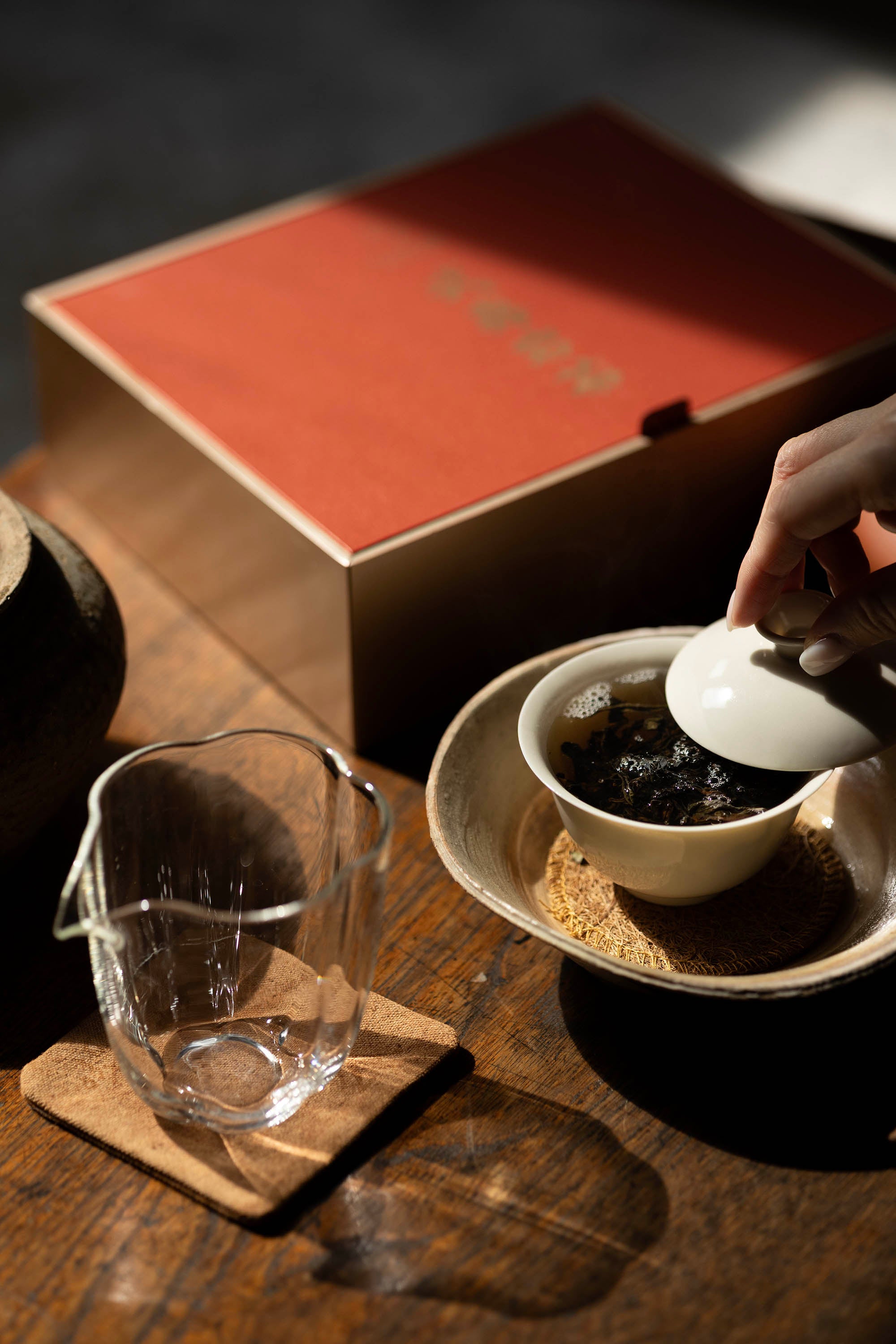 Brewing dark Wuyi Yancha wulong tea leaves in a white gaiwan using Gongfu Cha style with the &