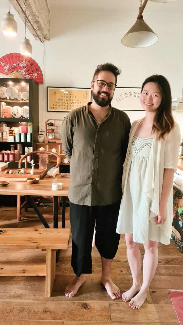 A man and a woman standing barefoot in a tea shop