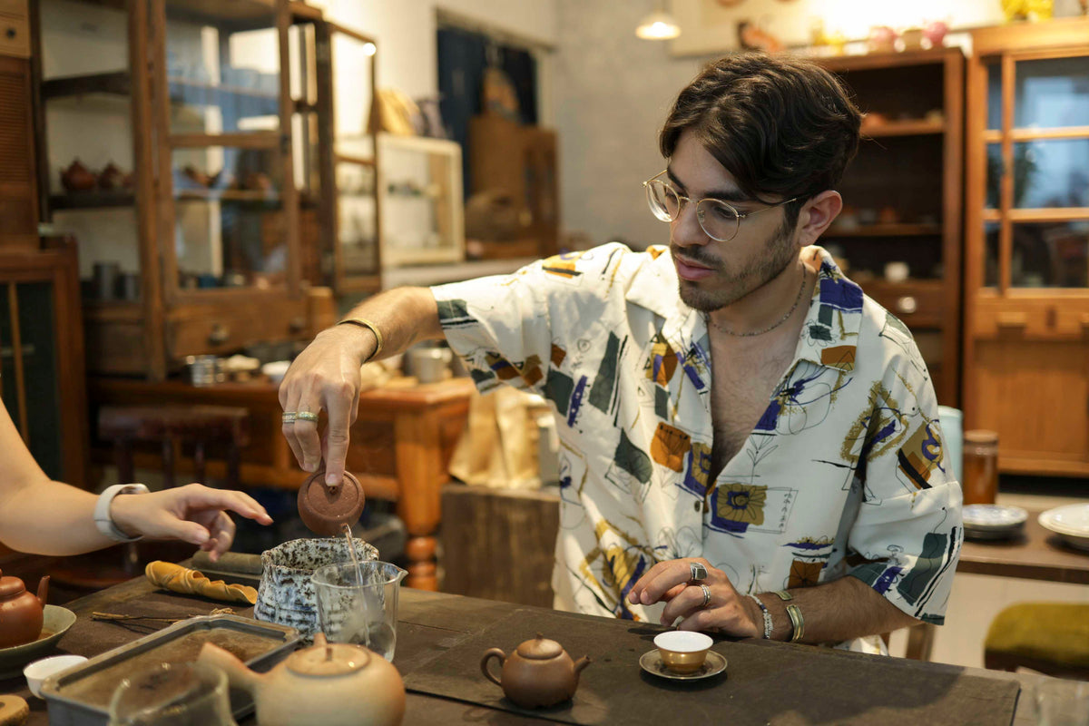 Ofek is serving tea in a tea collector's studio tea session outside Taipei city